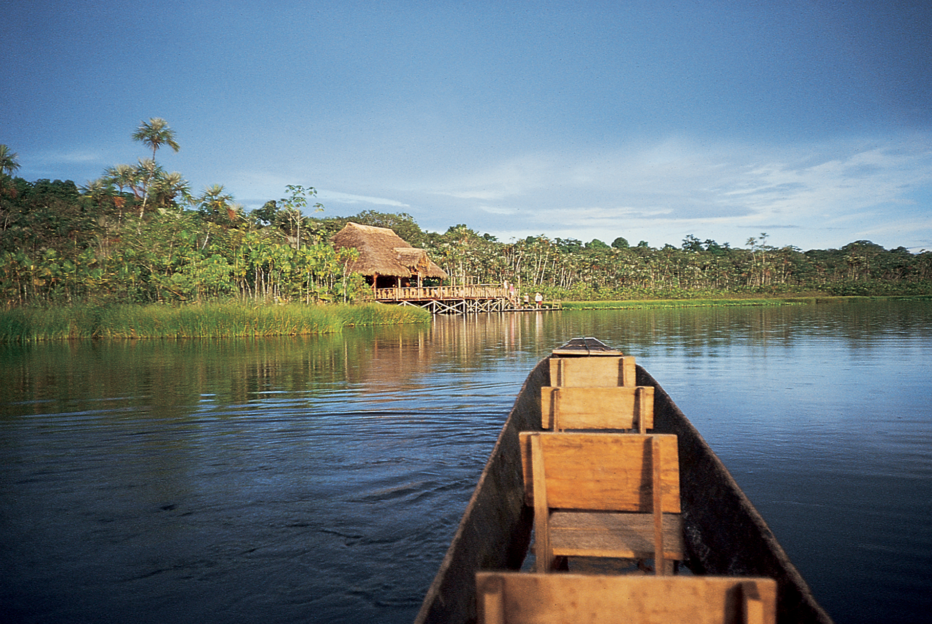 Paddeln in einem traditionellen Einbaum auf einem See im ecuadorianischen Amazonasgebiet. 35-mm-Original auf Fuji- Velvia-Film. Kunde: MT Sobek | Paddling a traditional dugout canoe on lake in Ecuadorian Amazon. 35mm original on Fuji Velvia film. Client: MT Sobek.