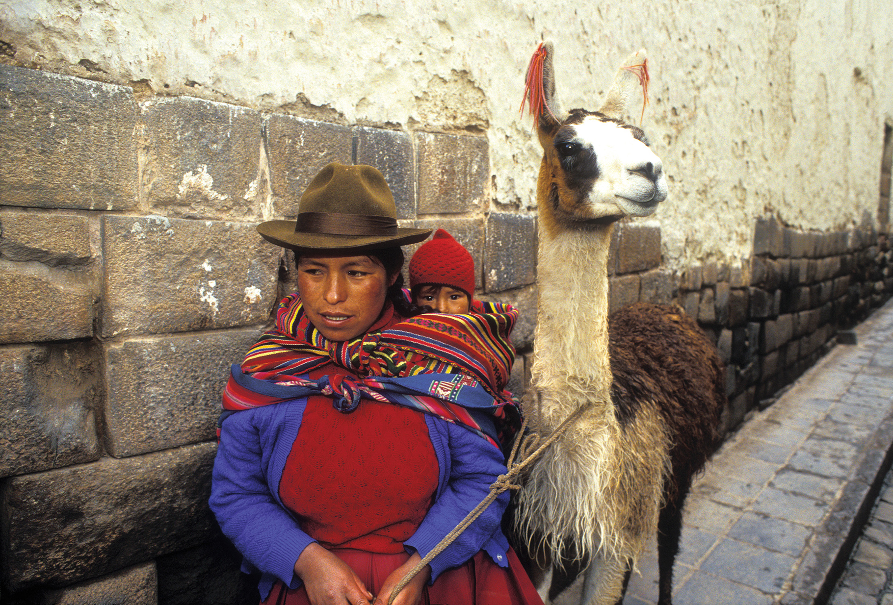 Quechua-Frau mit ihrem Kind und Lama. Cusco, Peru. 35-mm-Original auf Fuji-Velvia-Film. | Quechua woman with her child and llama. Cusco, Peru. 35mm original on Fuji Velvia film.